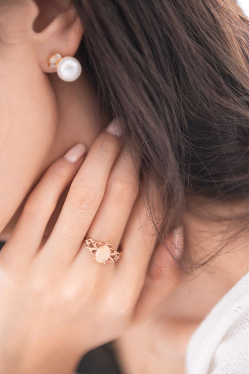 Showing pearl earrings and opal ring